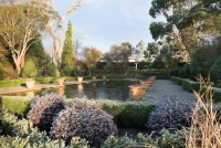 Winter in the formal Italianate garden at Borde Hill with a nude statue of a woman with outstretched arms in background