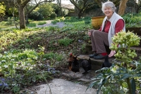 Mrs Elkington feeding her chickens in her garden in early spring