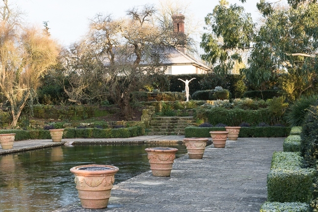 Terracotta containers around the edge of the frozen pool in the Italianate garden with rill in background