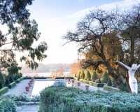 Winter in the formal Italianate garden at Borde Hill with a nude statue of a woman with outstretched arms in foreground