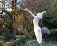Winter in the formal Italianate garden at Borde Hill with a nude statue of a woman with outstretched arms in foreground