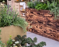 Outdoor kitchen area with raised beds containing herbs, vegetables and perennials
