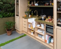 Outdoor kitchen area with raised beds containing herbs, vegetables and perennials