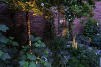 Lighting in a kitchen garden beside a pathway leading up to a Lean to conservatory