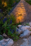 Lighting geometric basalt mounds in a contemporary mediterranean garden