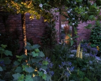 Lighting in a kitchen garden beside a pathway leading up to a Lean to conservatory