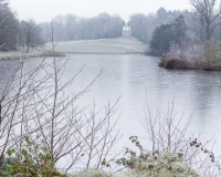 Painshill Park landscape garden overlooking the frozen lake with the Gothic Temple in the background