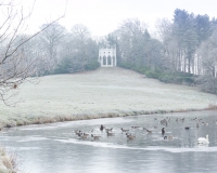 Painshill Park landscape garden overlooking the frozen lake with the Gothic Temple in the background