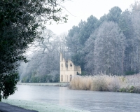 Painshill Park landscape garden overlooking the frozen lake with the Ruined Abbey in the background