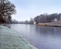 Painshill Park landscape garden overlooking the frozen lake with the Ruined Abbey in the background