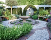 Circular water bowl surrounded by a carpet of Thyme in a modern herb garden