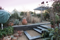 Steps made out of oak sleepers lead up to a different level in a gravel garden