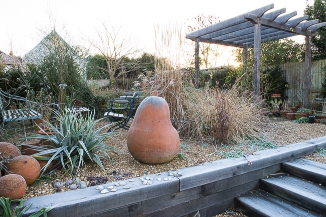 Steps made out of oak sleepers lead up to a different level in a gravel garden