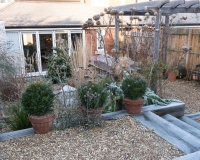 Frosty morning in a gravel garden, steps leading down to a lower level