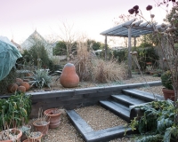 Steps made out of oak sleepers lead up to a different level in a gravel garden