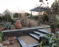 Steps made out of oak sleepers lead up to a different level in a gravel garden