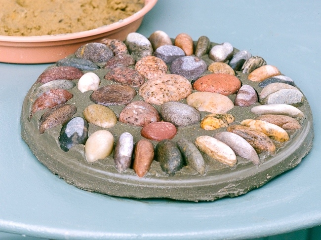Making a pebble mosaic pattern. 4. Once set tcarefully ease out the mosaic from the platic tray and wash off any sand that has styuck to the mosaic.